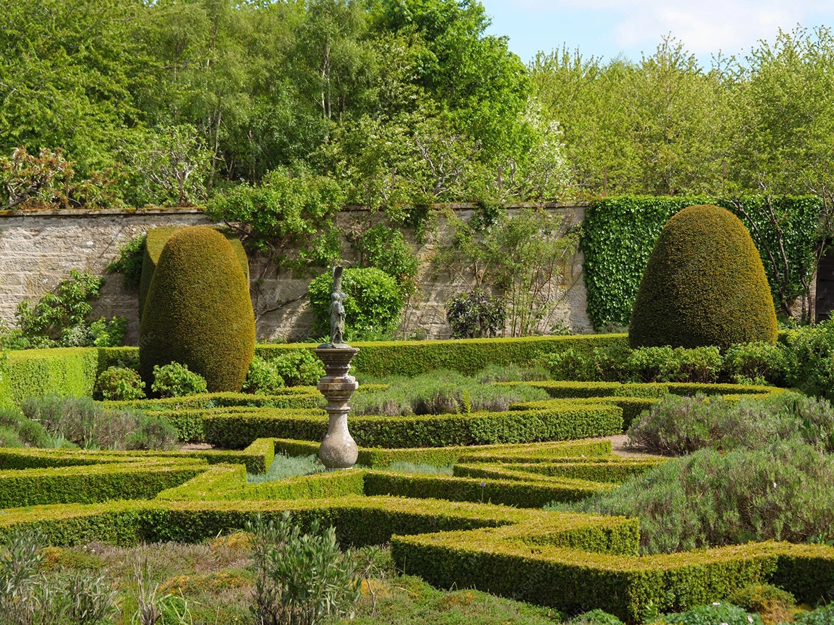 Photographie d'un jardin régulier à la française : tracé géométrique strict, parterres dessinés, perspectives axiales.